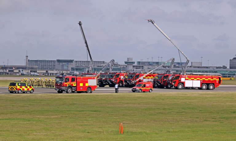 Line of red fire-rescue vehicles parked outdoors, used as an illustrative archive image