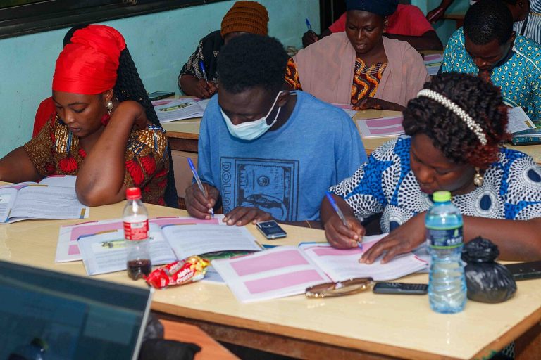 Adults seated in rows taking notes during an entrepreneurship seminar